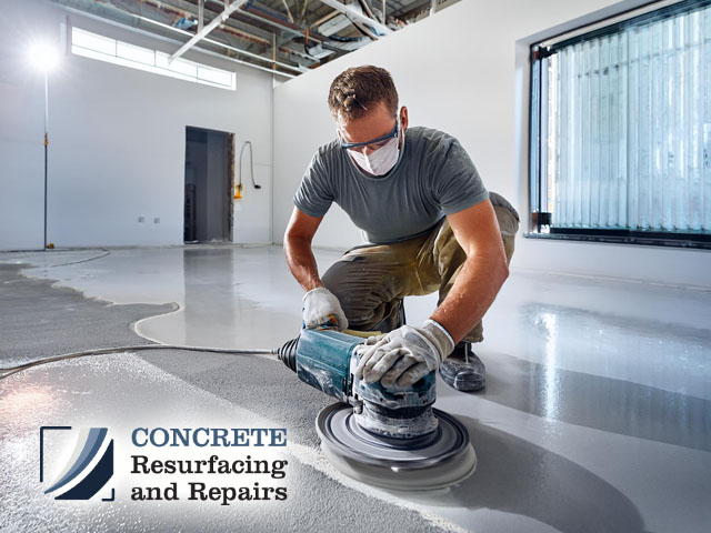 male professional technician working indoors performing expert concrete flooring surface preparation polishing for resurfacing